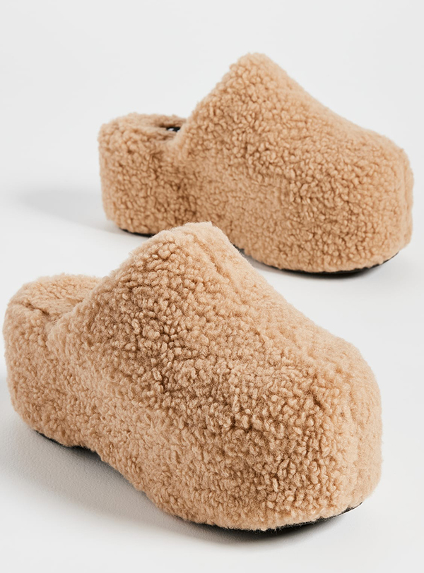 A pair of platform clogs lined with tan bouclé fabric
