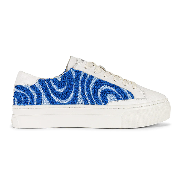 A white leather sneaker lined with blue bouclé spirals