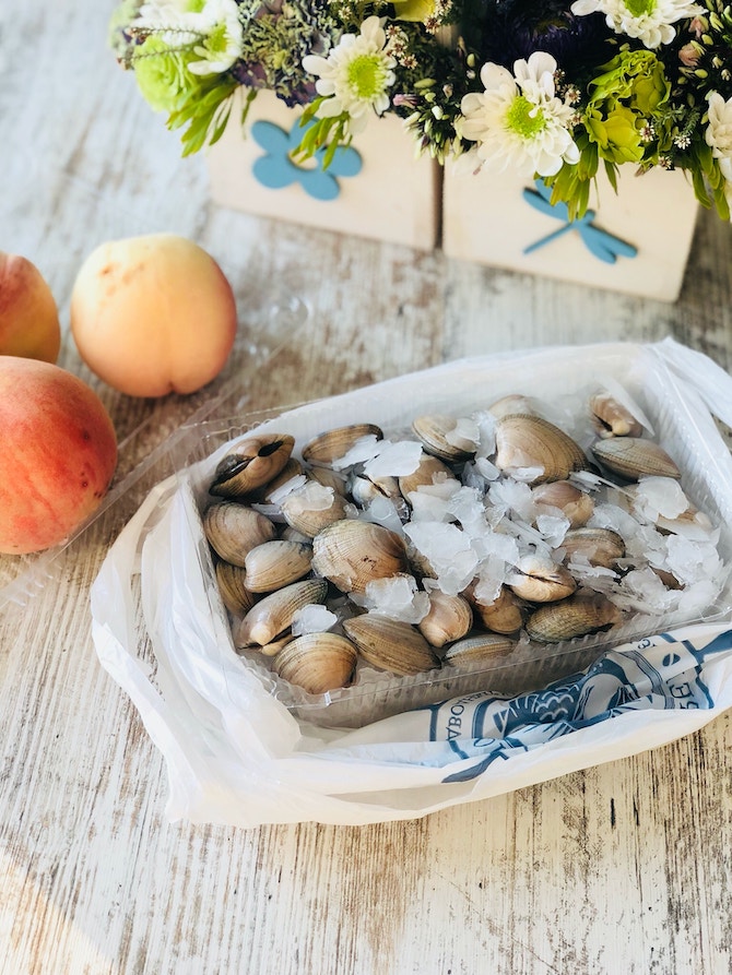 A table topped with clams on ice