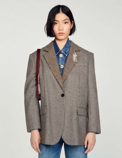 A model wearing a houndstooth blazer from Sandro