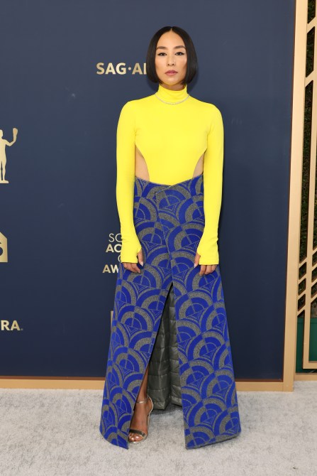 Greta Lee in a yellow turtleneck and blue printed skirt at the 2022 SAG Awards