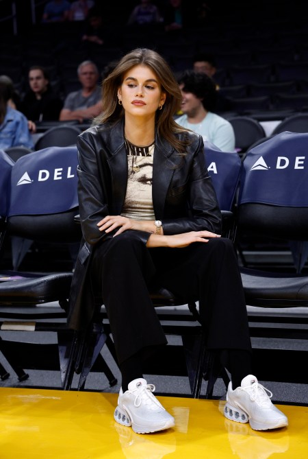 Kaia Gerber sitting court-side at a Lakers game wearing a leather blazer and Nike Airmaxes.