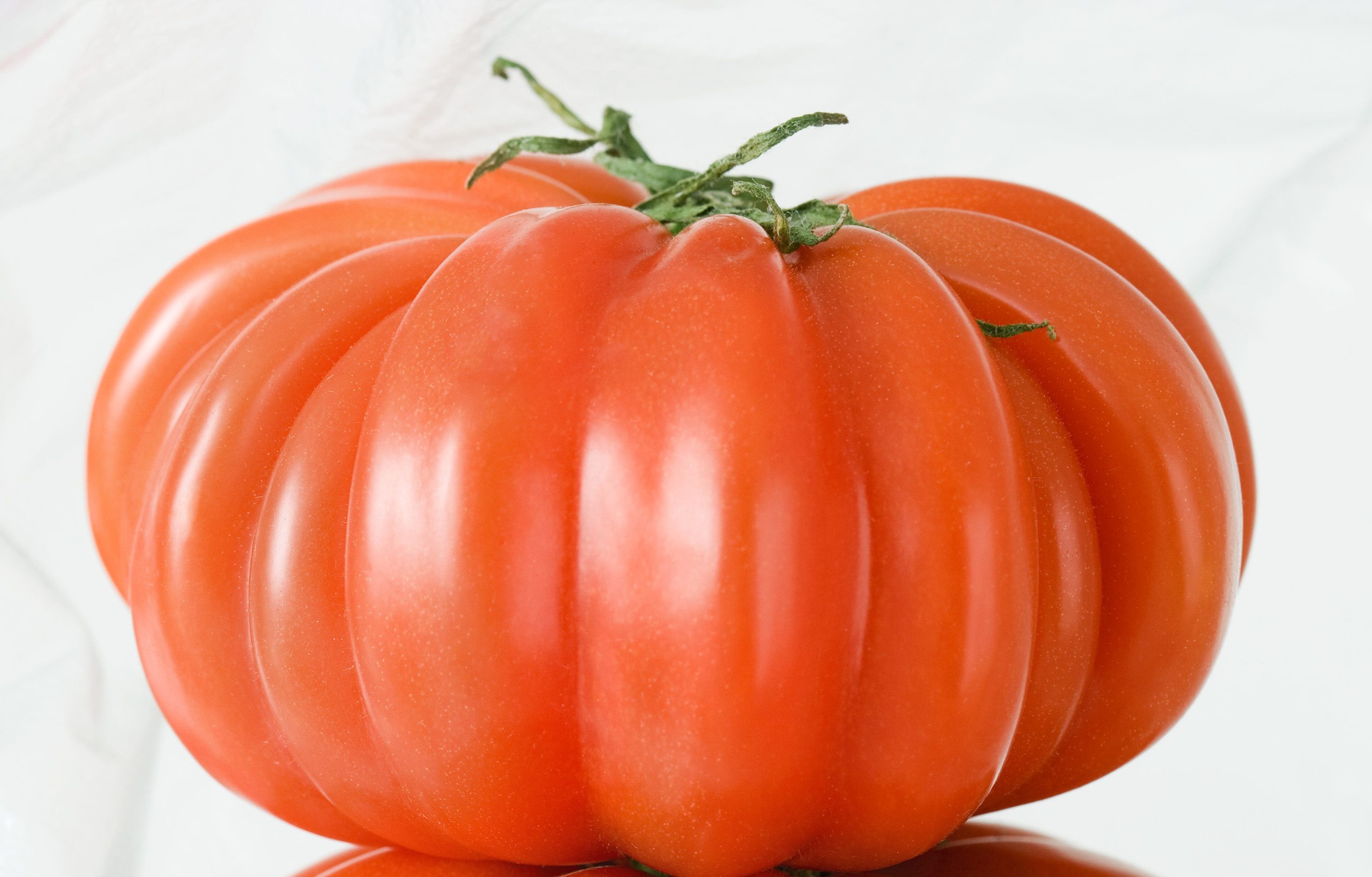Red heirloom tomato in a plastic bag.