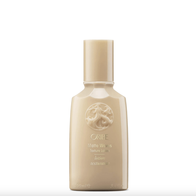 Oribe Matte Waves Texture Lotion in a gold bottle.