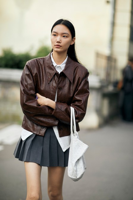 A fashion week guest wearing a pleated grey skirt.