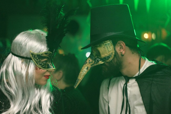 Two people in masks look at each other