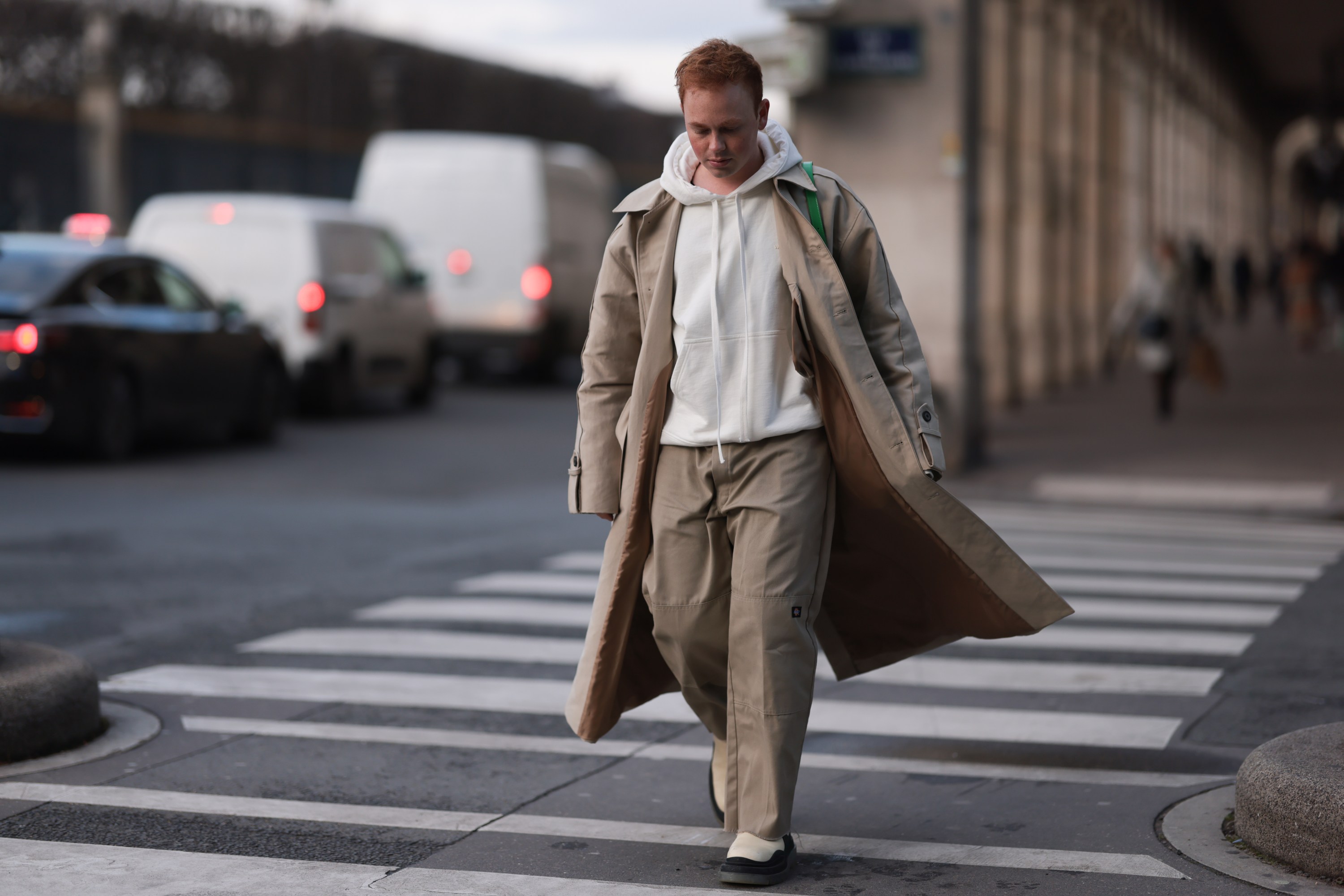 Erik Scholz seen wearing a ByFar green leather bag, a vintage beige trenchcoat, Dickies beige wide leg pants, Bottega Veneta beige leather boots and a 032C beige sweater on January 20, 2023 in Paris, France.