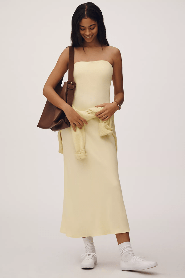 A model wearing the Anthropologie The Tilda Slip Dress in butter yellow