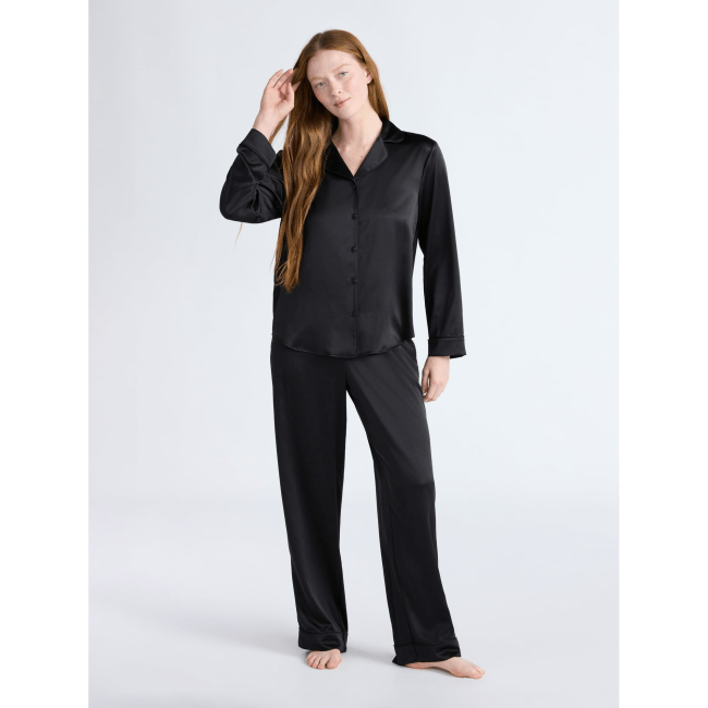 A model wearing the Joyspun Women’s Stretch Satin Notch Long Sleeve Top and Pants Pajama Set, 2-Piece in black