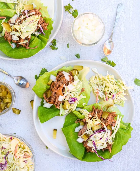 Plate of lettuce leaves filled pulled pork and coleslaw