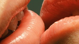 A close-up image of lips kissing