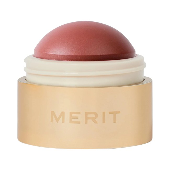 Merit Flush Balm Cream Blush in Cheeky in gold pot.