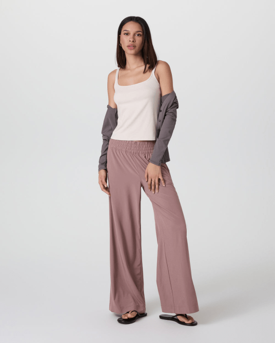 A model wearing the Vuori Villa Wideleg Pant in a dusty rose colorway