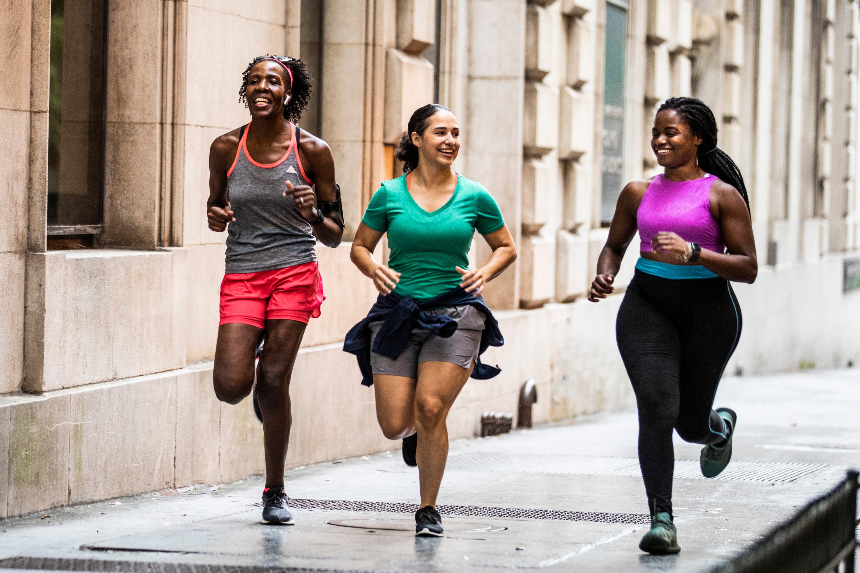 Group of women running through urban area