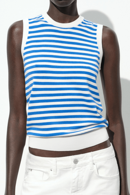 A model wearing the Zara Sleeveless Knit Top in a blue and white stripe pattern