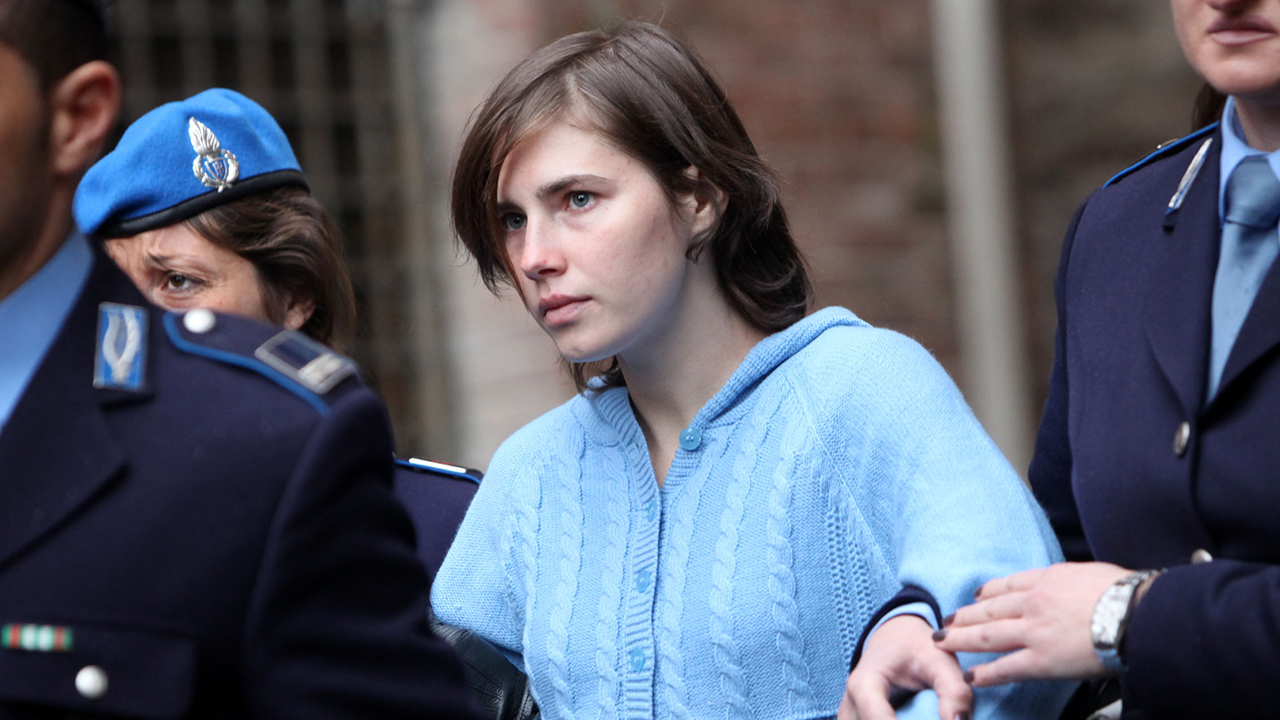 PERUGIA, ITALY - NOVEMBER 24:  Amanda Knox is led away from Perugia's court of Appeal by police officers after the first session of her appeal against her murder conviction on November 24, 2010 in Perugia, Italy. American Amanda Knox and her Italian ex-boyfriend Raffaele Sollecito were convicted of the murder of Ms Knox's former British flatmate Meredith Kercher in 2007. Their trial took place in December 2009 with Knox and Sollecito receiving sentences of 26 and 25 years respectively. Rudy Guede, an unemployed man from Ivory Coast, was also convicted of the Meredith Kercher's murder. The case is also forming the basis for a film currently being shot in Italy entitled 'The Amanda Knox Story', with American actress Hayden Panettiere cast as Amanda Knox