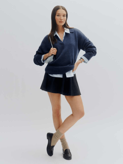 A model wearing Reformation's Sawyer Oversized Cashmere Polo in a dark blue colorway