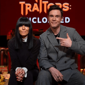 The Traitors host Claudia Winkleman and The Traitors: Uncloaked host Ed Gamble sitting next to each other on set for The Traitors: Uncloaked official visualized podcast